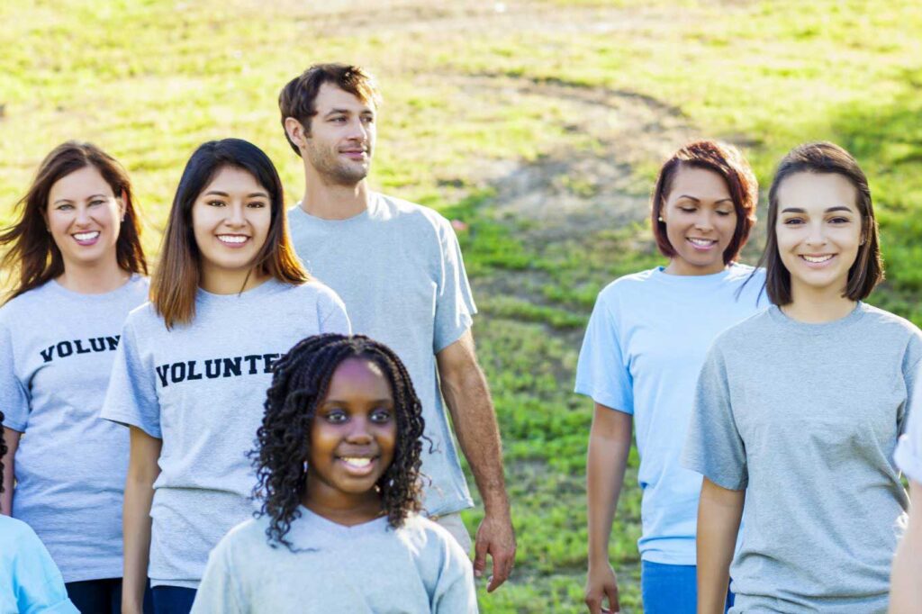 Group of volunteers smiling in a field together